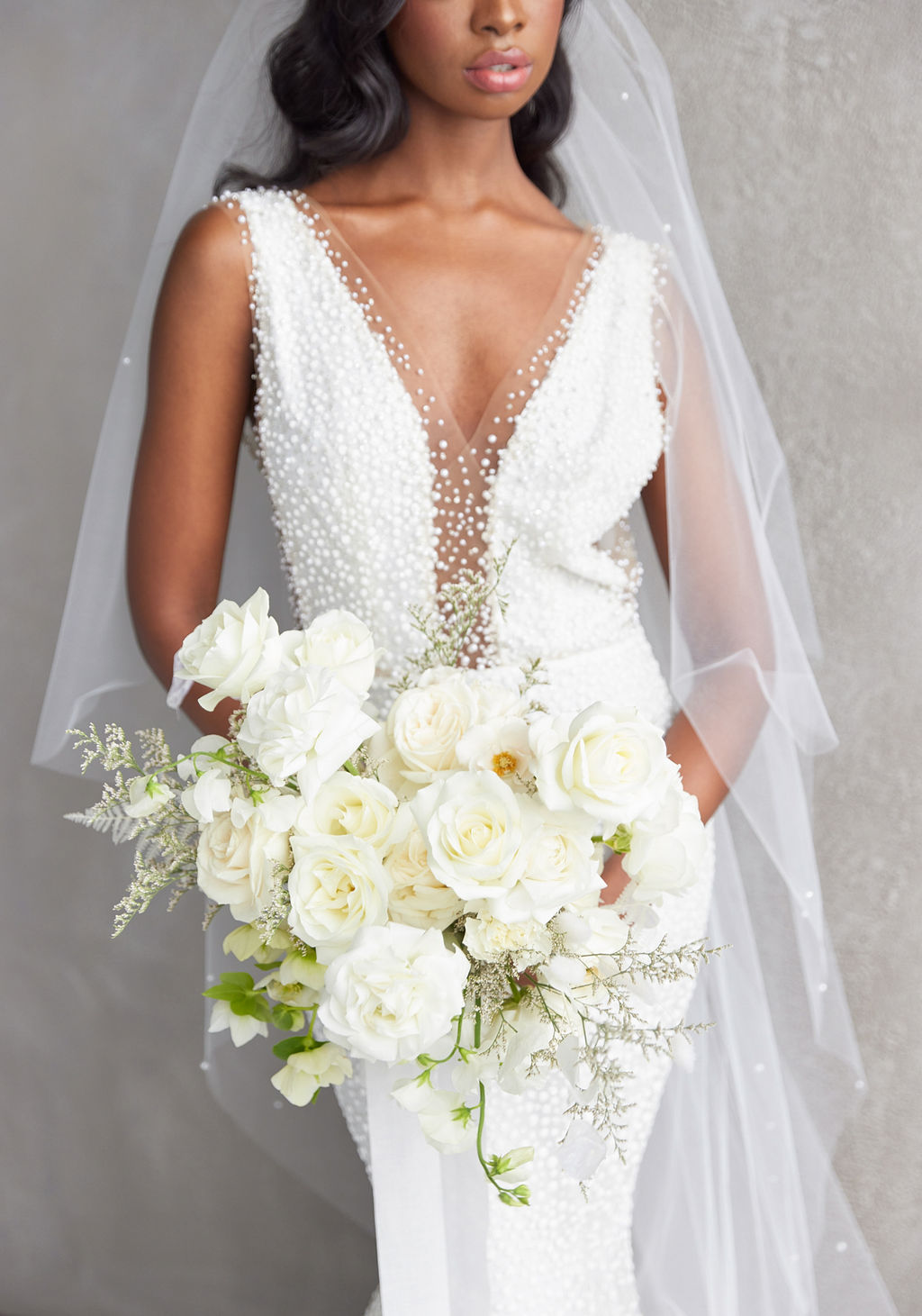 Bride wearing a wedding dress and holding a white rose bouqet
