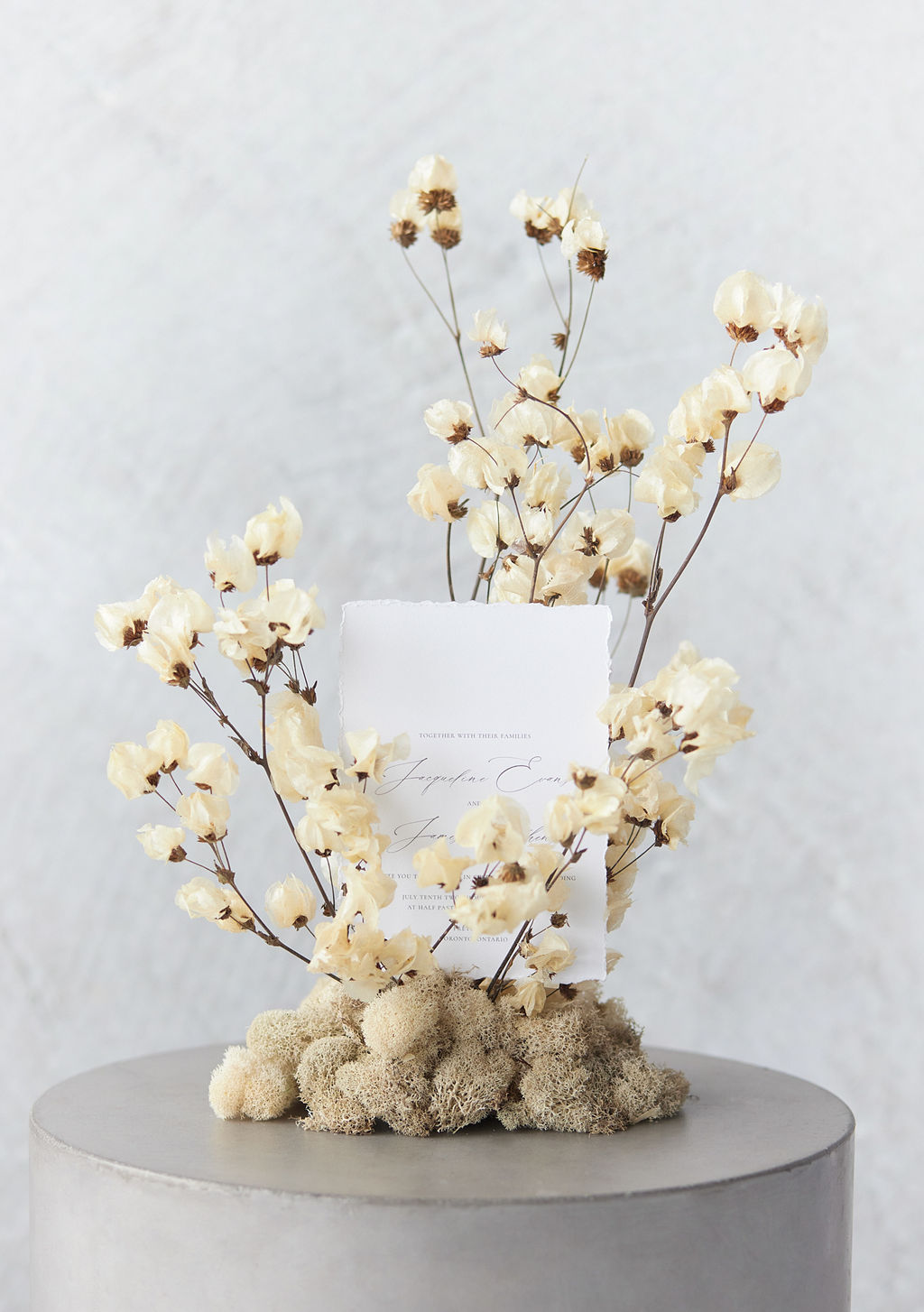 Beige dry flower stand with an event invitation card