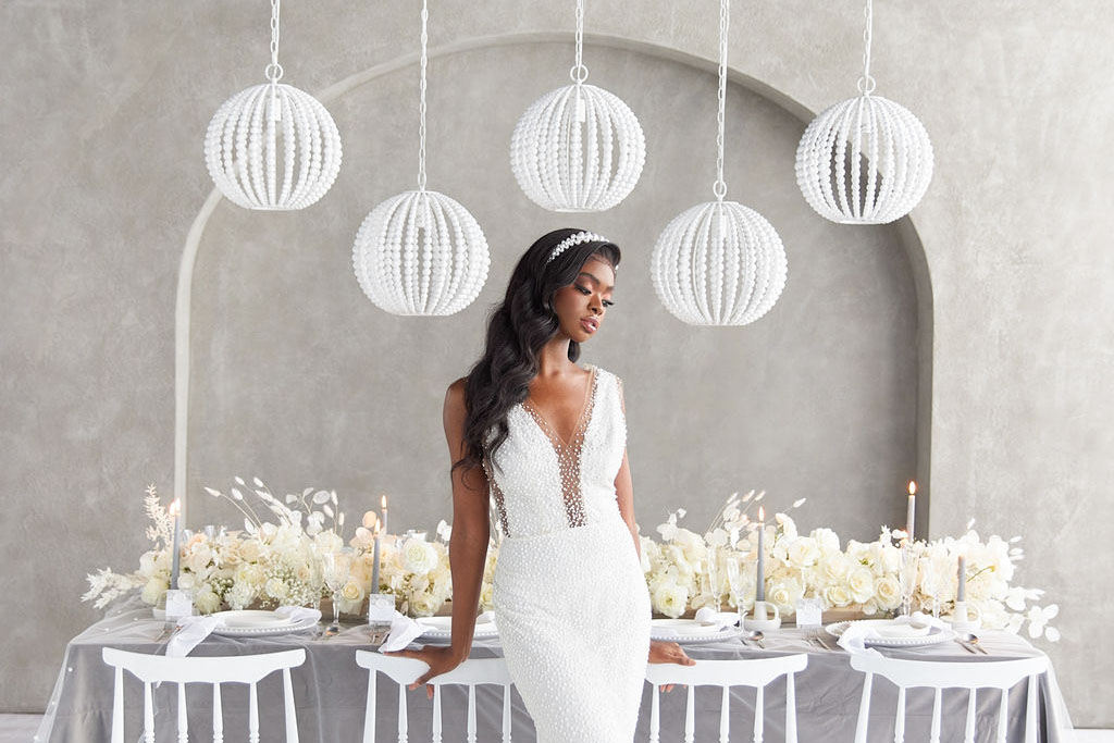 Modern wedding ceremony setup with a bride wearing an elegant pearl dress in a grey loft space