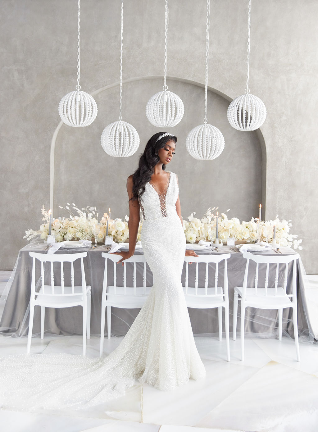 Bride posing in front of the wedding table with pearl decor pieces